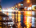 Rainstorm night in the big city, light from the shop windows reflected on the road Royalty Free Stock Photo