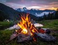 A vibrant campfire surrounded by rocks burns brightly in the foreground Royalty Free Stock Photo