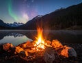 A campfire burns brightly in the foreground, surrounded by a circle of rocks Royalty Free Stock Photo