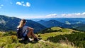 Woman hiker sits and enjoys valley view from viewpoint. Hiker reached top of the moun Royalty Free Stock Photo