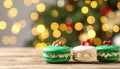 Beautifully decorated Christmas macarons on wooden table against blurred festive Royalty Free Stock Photo