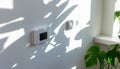 Modern Indoor Thermostat On Light Wall With Plant Shadows And Sunlight. Royalty Free Stock Photo