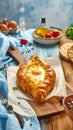 Delicious hachapuri filled with cheese and eggs, and a wooden table covered Royalty Free Stock Photo