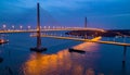 Illuminated Cable-Stayed Bridge at Dusk with Cargo Ship Royalty Free Stock Photo