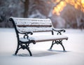 Wooden bench covered in snow at sunrise or sunset, casting long shadows on the ground Royalty Free Stock Photo