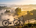 Two bicycles are parked along a rural roadside against a backdrop of mist-covered rolling hills Royalty Free Stock Photo