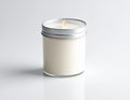 A white candle is housed in a glass jar with a silver metal lid Royalty Free Stock Photo