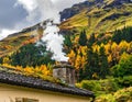 Chimney of a house with smoke rising against a backdrop of lush Royalty Free Stock Photo