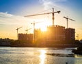 High-rise buildings under construction are silhouetted against the setting sun Royalty Free Stock Photo
