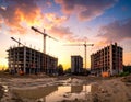 A construction site at sunset features three unfinished multi-story buildings Royalty Free Stock Photo