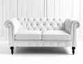 White Chesterfield-style sofa with tufted back and armrests, featuring button detailing Royalty Free Stock Photo