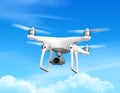 A white quadcopter drone with four propellers flies against a bright blue sky Royalty Free Stock Photo
