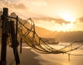 Fishing net strung between wooden poles on a beach at sunset Royalty Free Stock Photo