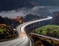 A winding highway bridge stretches across a verdant landscape shrouded in mist Royalty Free Stock Photo
