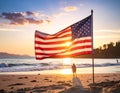 An American flag waves prominently on a sandy beach as the sun sets Royalty Free Stock Photo