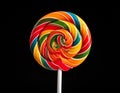 A colorful, spiral lollipop features vibrant hues of red, orange, yellow, green, and blue Royalty Free Stock Photo