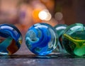 Colorful glass marbles with swirling patterns sit on a textured surface Royalty Free Stock Photo