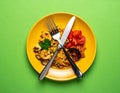 A meal in the center with a fork and a knife crossed under the plate. for colors Royalty Free Stock Photo