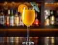 Yellow drink in champagne flut glass at the bar. There is an orange slice Royalty Free Stock Photo