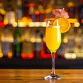 Yellow drink in champagne flut glass at the bar. There is an orange slice Royalty Free Stock Photo