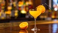 Yellow drink in champagne flut glass at the bar. There is an orange slice Royalty Free Stock Photo