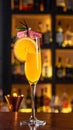 Yellow drink in champagne flut glass at the bar. There is an orange slice Royalty Free Stock Photo