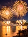 Spectacular golden fireworks illuminate a night sky, reflecting on a calm body of water. Royalty Free Stock Photo