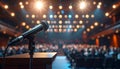 Microphone stands center stage under a bright spotlight, ready for a live music concert in an entertainment venue. Royalty Free Stock Photo