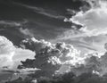 Dramatic black-and-white depiction of towering cumulonimbus and wispy cirrus clouds against a dark sky Royalty Free Stock Photo