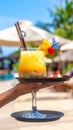 Generates the image of a hand holding a tray with tropical drinks and the hotel backg Royalty Free Stock Photo