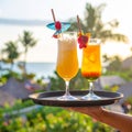 Generates the image of a hand holding a tray with tropical drinks and the hotel backg Royalty Free Stock Photo