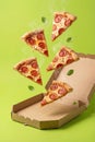 Flying Pepperoni Pizza Slices Hovering Above Open Box On Bright Green Background Royalty Free Stock Photo