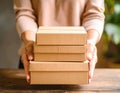Woman holding empty cardboard boxes on a dark wooden background. Creating a model Royalty Free Stock Photo