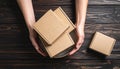 Woman holding empty cardboard boxes on a dark wooden background. Creating a model Royalty Free Stock Photo