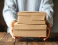 Woman holding empty cardboard boxes on a dark wooden background. Creating a model Royalty Free Stock Photo