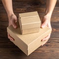 Woman holding empty cardboard boxes on a dark wooden background. Creating a model Royalty Free Stock Photo