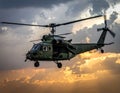 A military helicopter in flight against a dramatic sunset sky Royalty Free Stock Photo
