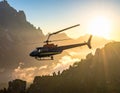 A helicopter flies across a dramatic mountainous landscape during sunset Royalty Free Stock Photo