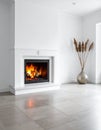 White room featuring a sleek, modern fireplace with a roaring fire, creating a warm ambiance Royalty Free Stock Photo