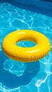 Yellow pool float, floating ring in a refreshing blue swimming pool. Royalty Free Stock Photo