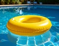 Yellow pool float, floating ring in a refreshing blue swimming pool. Royalty Free Stock Photo
