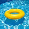 Yellow pool float, floating ring in a refreshing blue swimming pool. Royalty Free Stock Photo