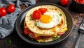 Close-up of a stack of tortillas with egg, sausage and tomatoes on a plate on a table Royalty Free Stock Photo