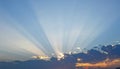 Sunrise dramatic blue sky with orange sun rays breaking through the clouds. Royalty Free Stock Photo