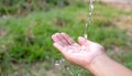 Water pouring in human hand on nature, environment issue. Water pouring in woman hand Royalty Free Stock Photo