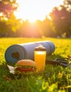 A rolled up yoga mat in the park. A jump rope next to it. In the foreground a delicios Royalty Free Stock Photo