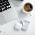 Modern wireless earphones and laptop on light table Royalty Free Stock Photo