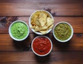Assorted Salsas and Tortilla Chips on Wooden Table Royalty Free Stock Photo