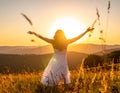 Happy woman on sunset in nature iwith open hands. Happy woman on the sunset in nature Royalty Free Stock Photo