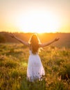 Happy woman on sunset in nature iwith open hands. Happy woman on the sunset in nature Royalty Free Stock Photo